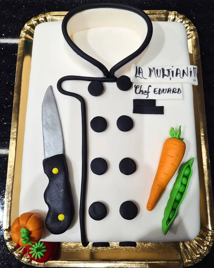 Tort în formă de halat de bucătar, cu cuțit și legume din fondant