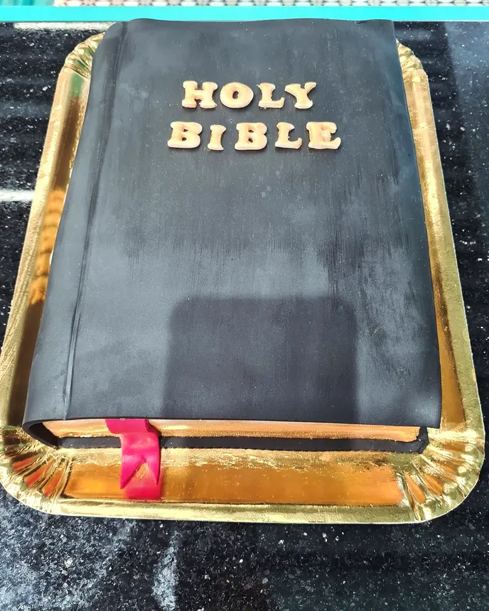 Tort în formă de Biblie, îmbrăcat în fondant negru, cu litere aurii