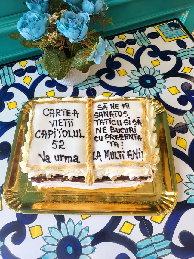 Tort în formă de carte deschisă, cu un mesaj scris pe pagini
