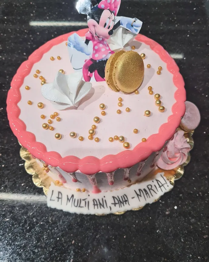 Tort roz cu perle aurii și un macaron auriu deasupra