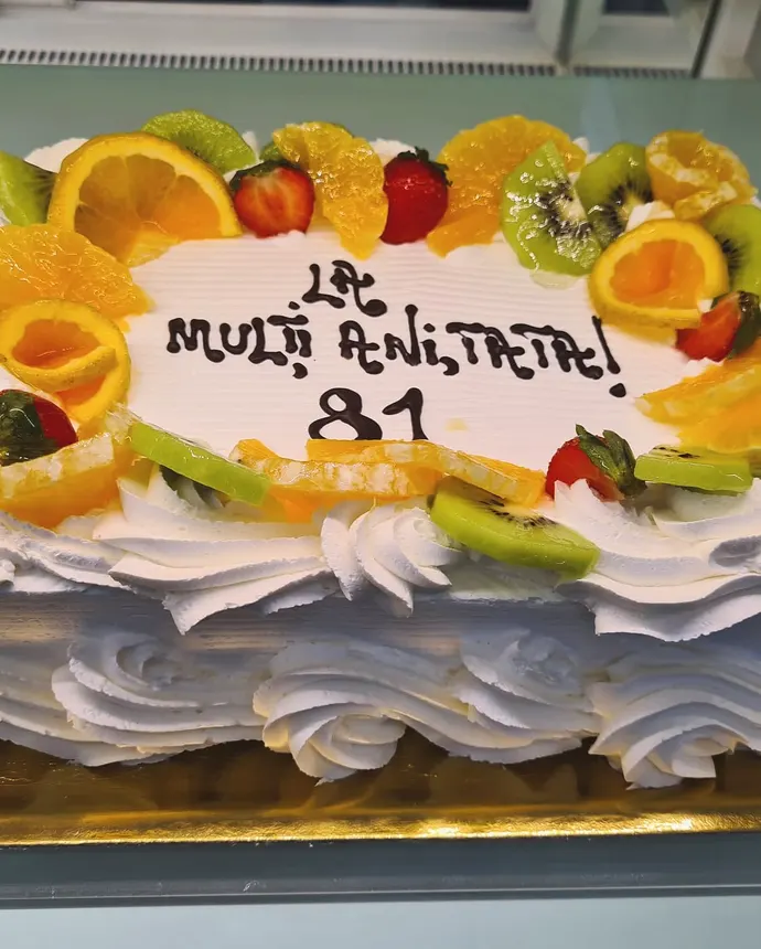 Tort dreptunghiular cu felii de portocală, kiwi și căpșuni pe margine