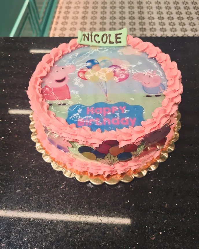 Tort roz cu Peppa Pig, cu numele Nicole scris deasupra