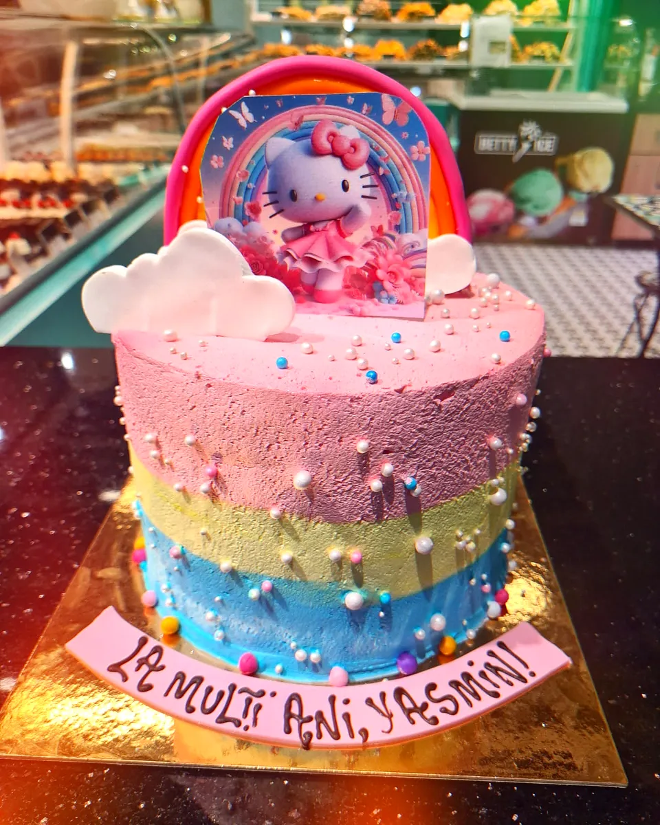 Tort curcubeu în trei culori, cu Hello Kitty și nori albi din fondant